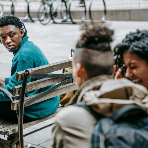 couple of students gossiping and laughing near black man